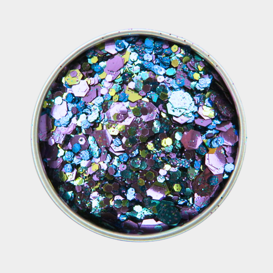 Multicolored glitter in a round container on a light gray background
