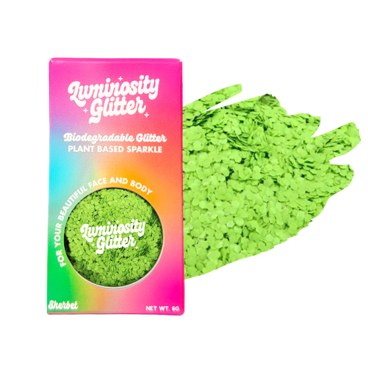 Green glitter and packaging with 'Luminosity Glitter' branding on a white background