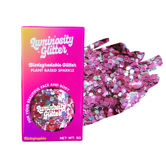 Biodegradable glitter packaging with pink and holographic glitter on a white background