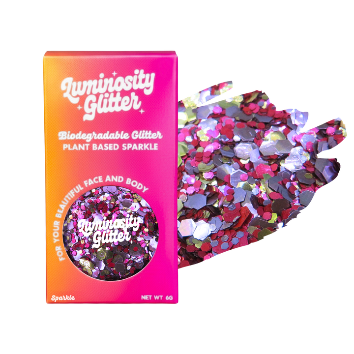 Luminosity Glitter packaging with biodegradable and plant-based sparkle, next to a handful of glitter on a white background.
