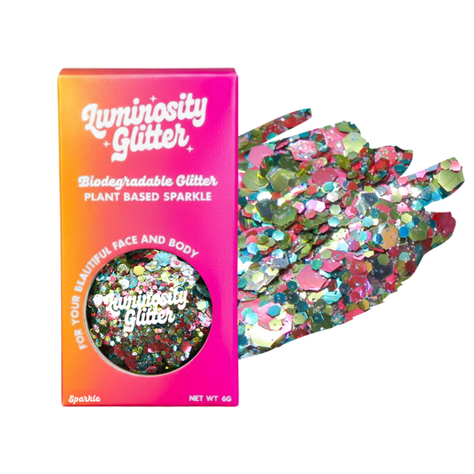 Luminosity Glitter packaging with biodegradable and plant-based sparkle, next to a handful of colorful glitter.