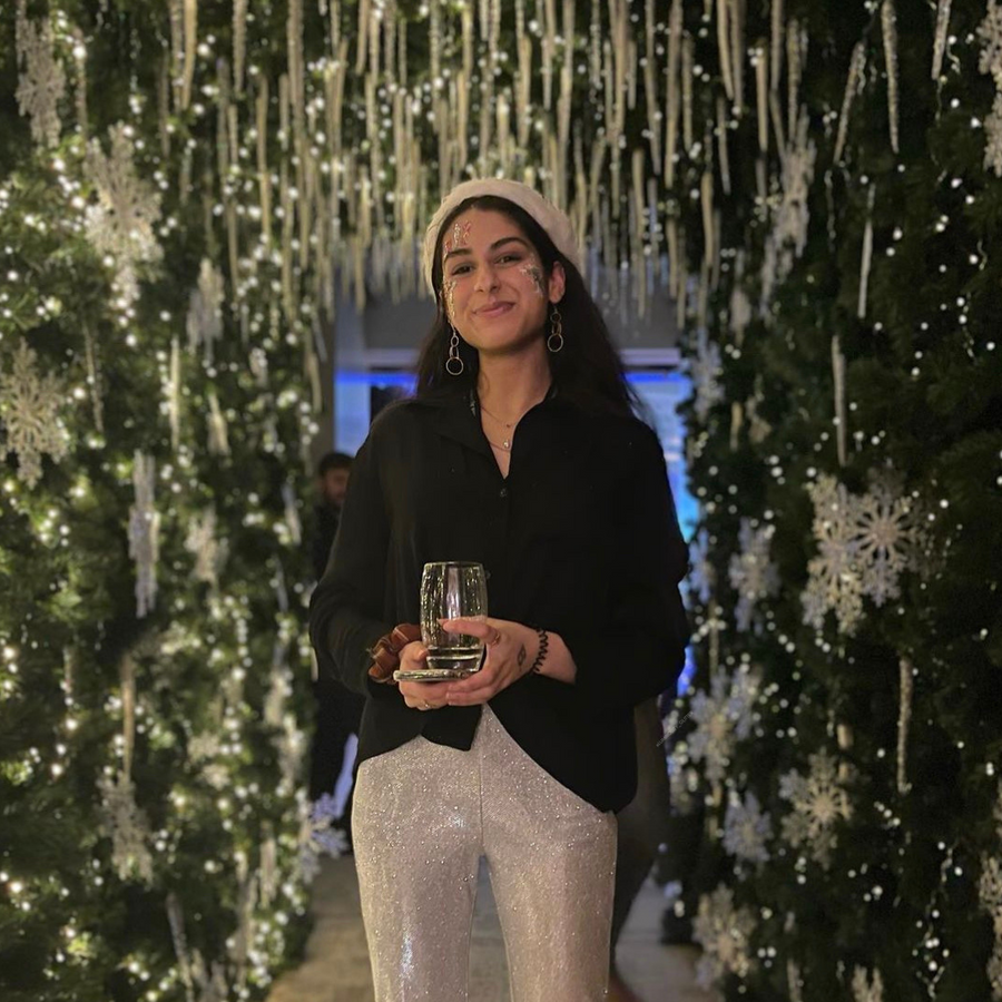 A guest standing in a snowflake fairy light walkway at one Moorgate place for a festive glitter bar