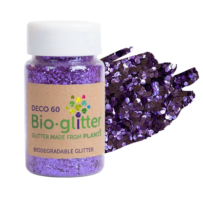 A jar of purple chunky craft Bio-glitter with a white cap and a kraft paper label, shown next to a pile of loose purple glitter on a white background.