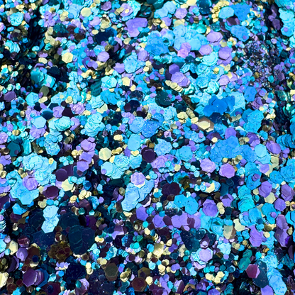 Colorful glitter mix in blue, purple, and gold on a dark background