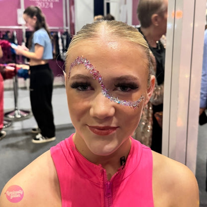 Person with face paint at an event, wearing a pink top.