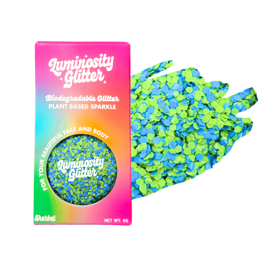 Biodegradable glitter packaging with a colorful box and green glitter on a white background