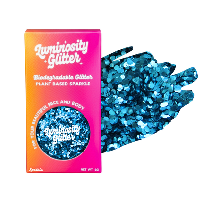 A pot of blue chunky biodegradable glitter in a bright pink and orange ombre box